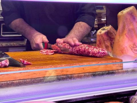 A man cutting cured meats.