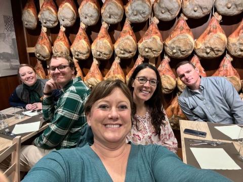 Another group photo in front of racks of curing hams.