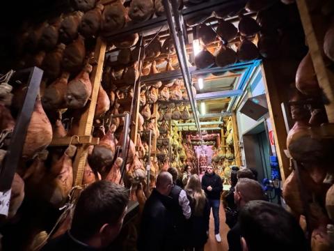 A group photo inside a ham curing room.