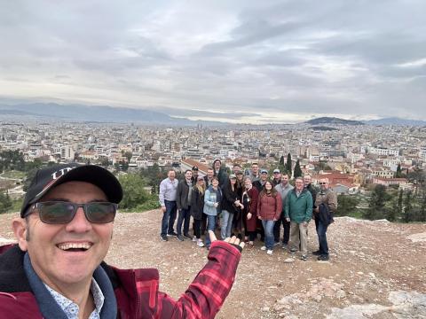 A group selfie with the city of Athens in the background.