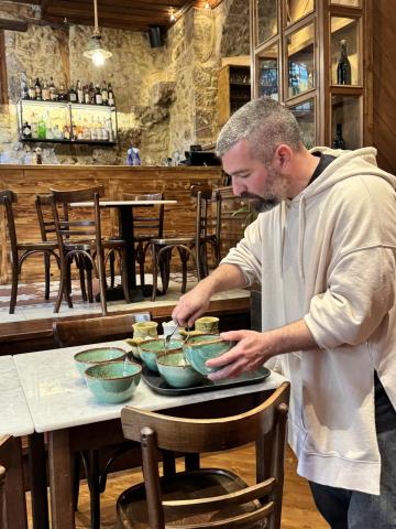 A man arranging dish ware in a restaurant.