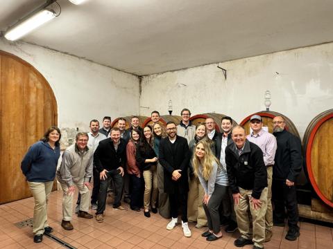 Lead group photo in a wine cellar.