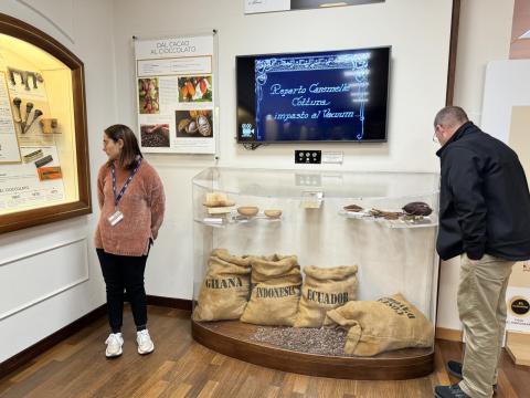 Two people examine a display in a chocolate factory.